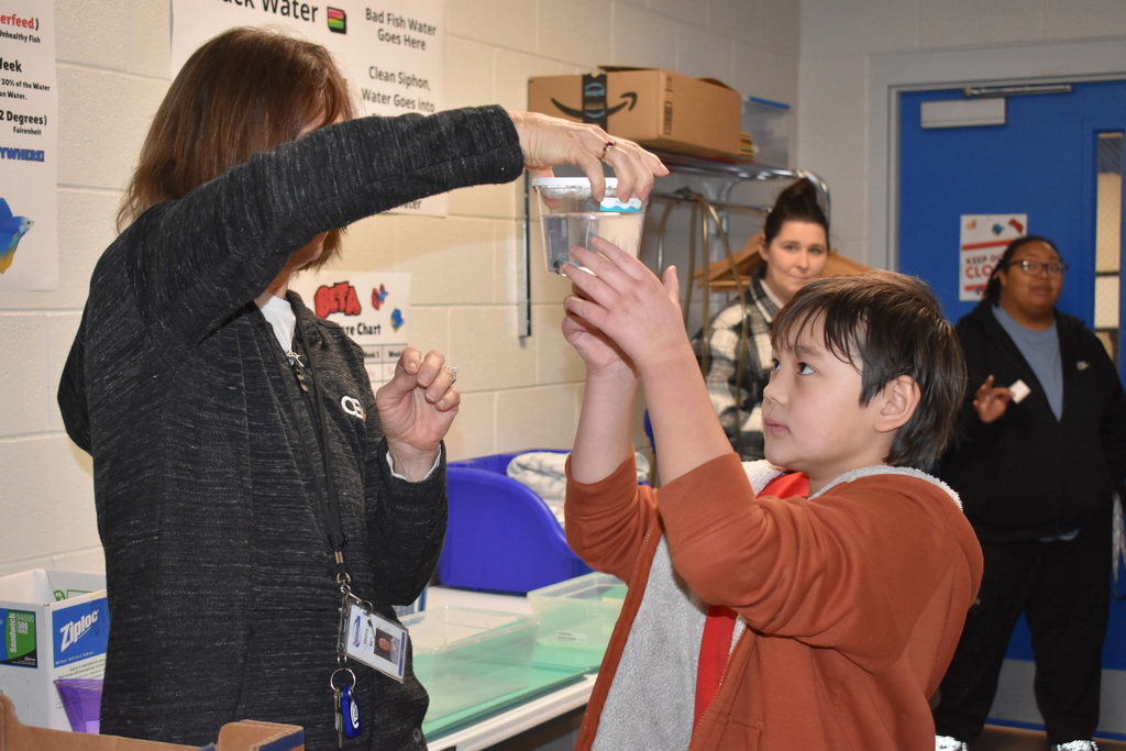 A student accepting his new fish from the instructor