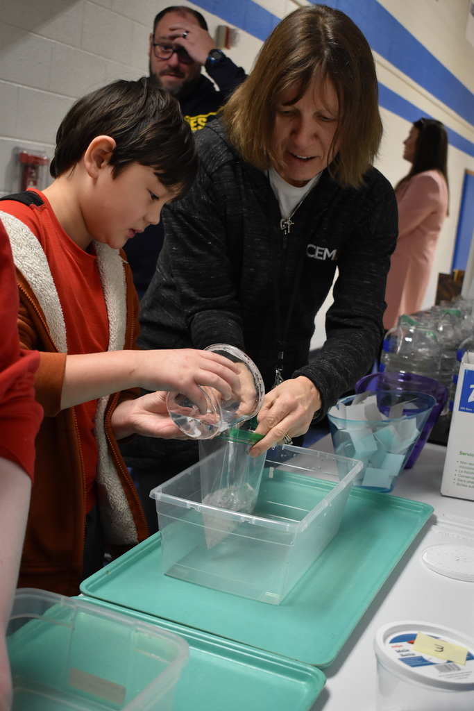 A student transferring his fish to a zip lock bag