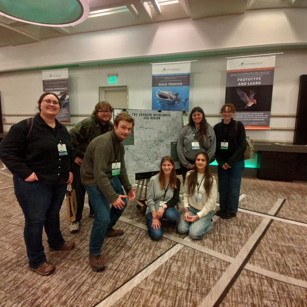 Students standing in front of the poster they presented on the Jackson Interlobate Region.