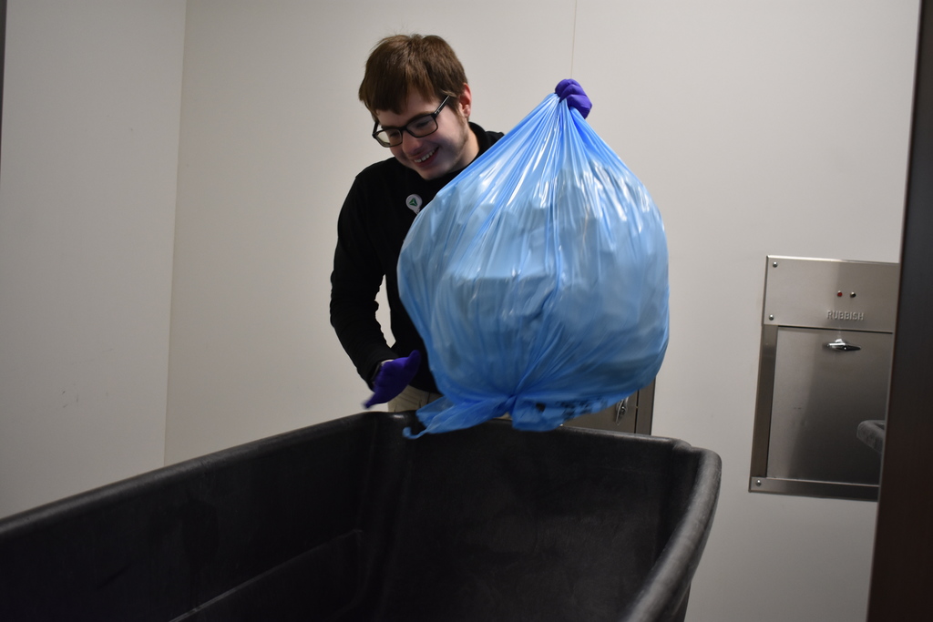 Project SEARCH student putting soiled linens in the proper place