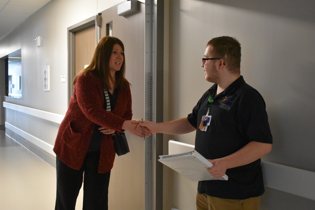 Beth McCary from Goodwill shaking the hand of a student