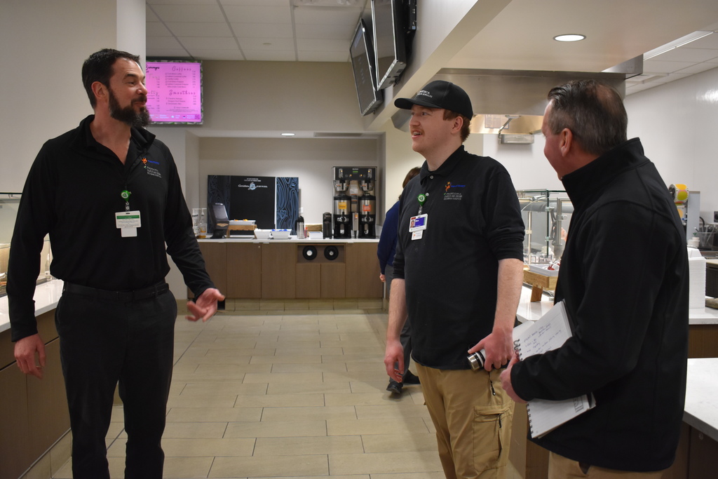 A student chatting with Glen and the CEO of Goodwill