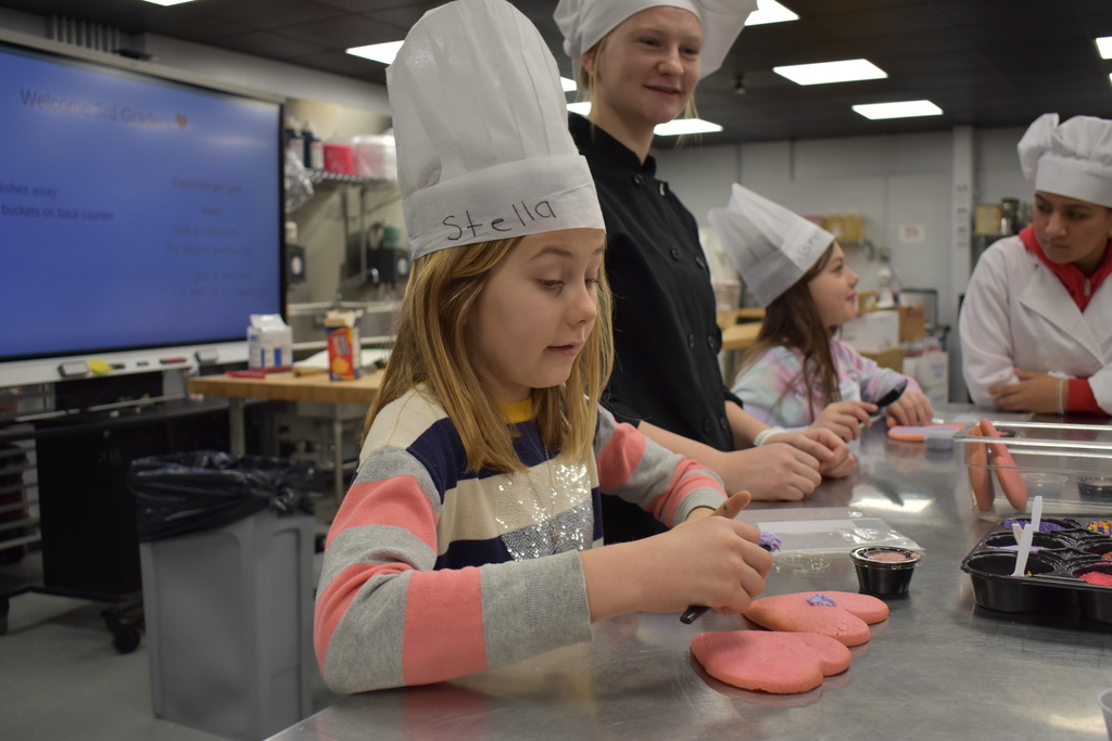 a student decorating a cookie 
