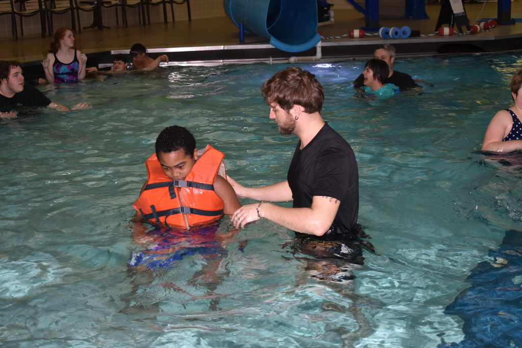 a student practicing his swimming with his insructor