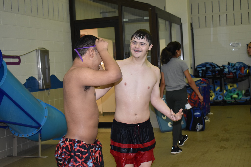 Two students chatting outside the pool before jumping in