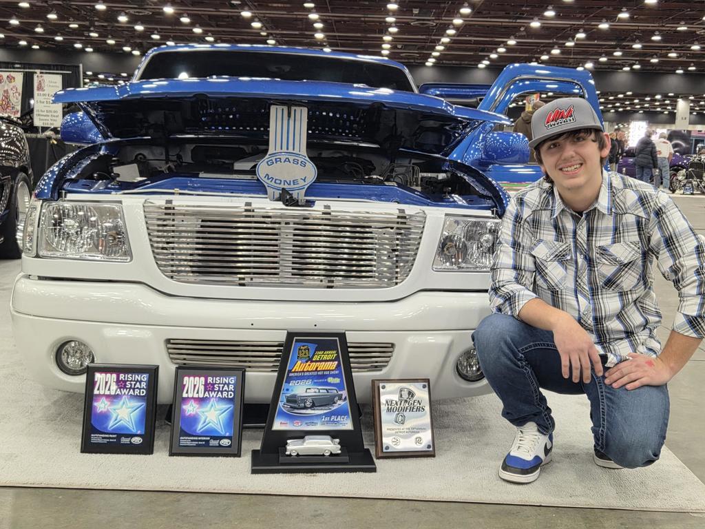Carter posing with his awards and his vehicle he was showcasing