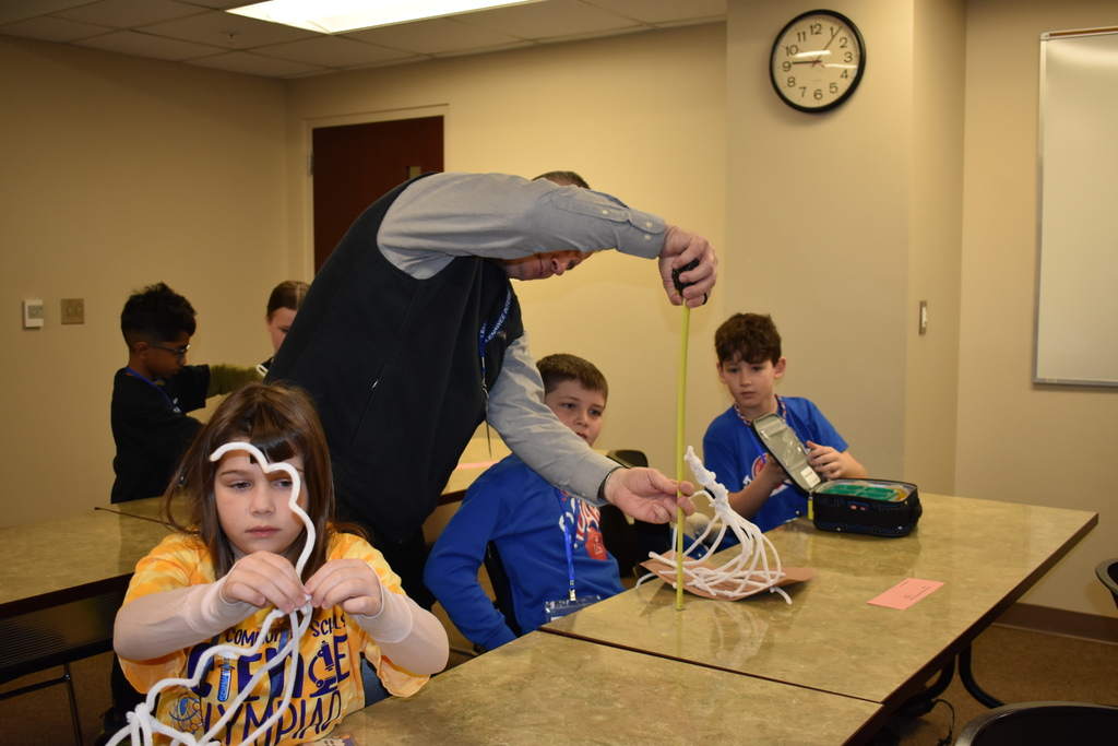 Students building and a judge measuring