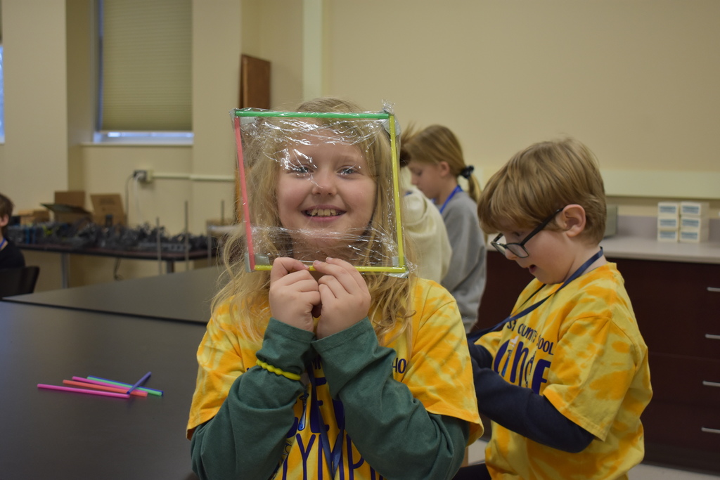 A student holding up her boat of straw and saran wrap