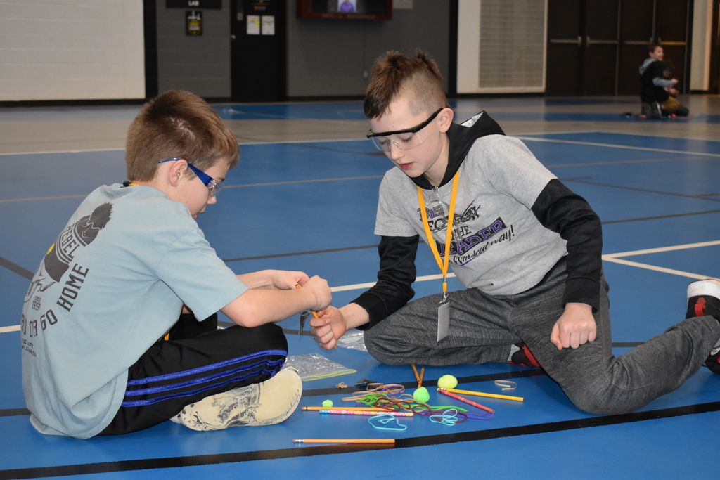 Two students creating a catapult 