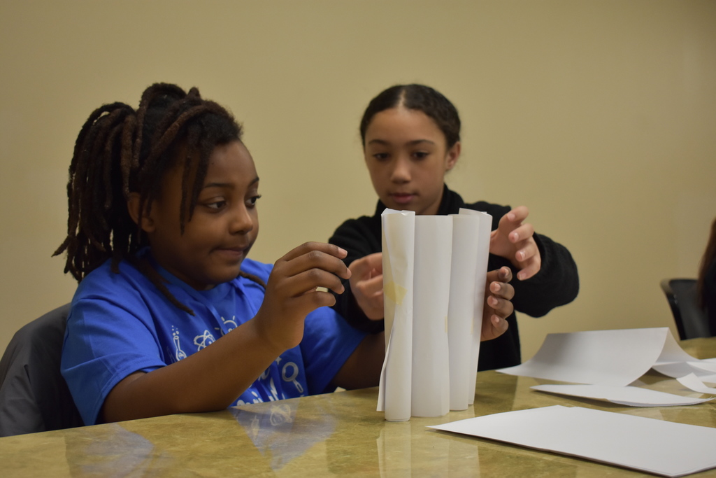 Two students testing their theory with paper