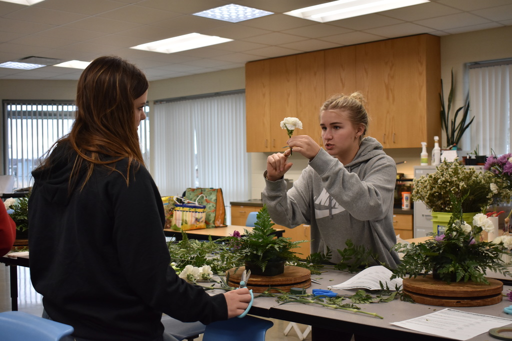 a student demonstrating floral arrangement work