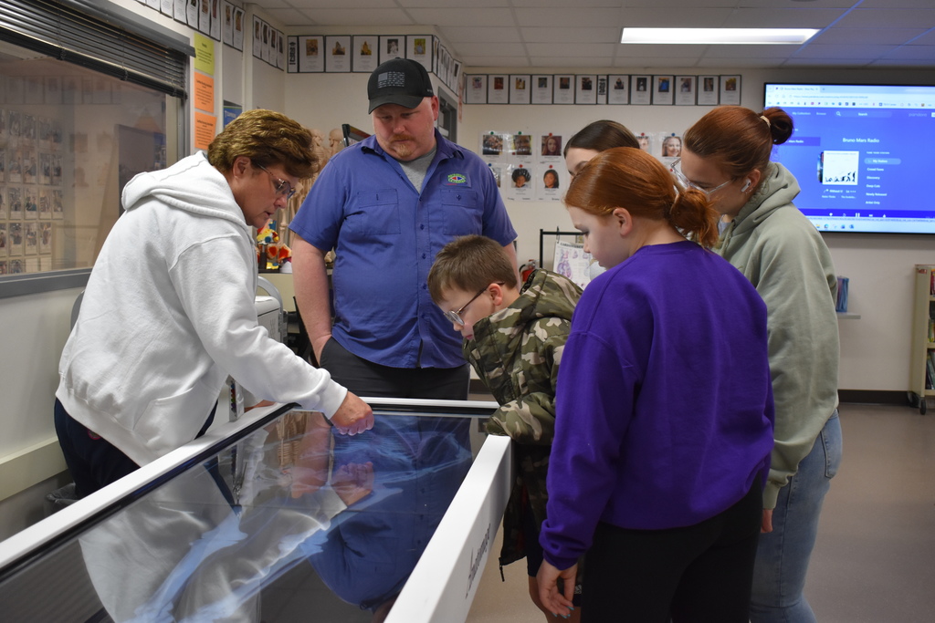 Lisa Dunlap demonstrating a medical device to a family