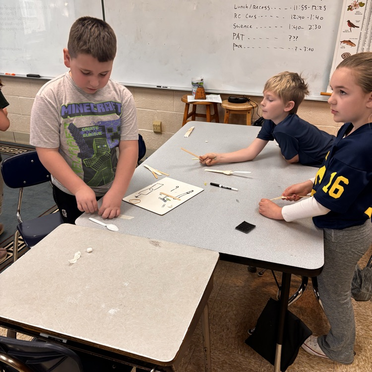 students stand by a table to