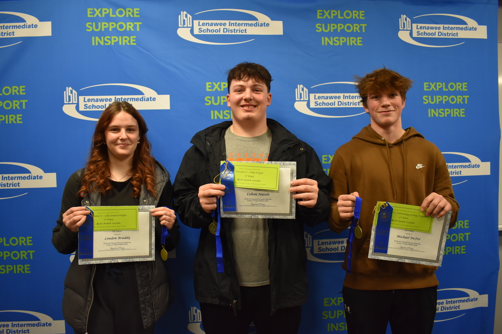 three students holding their first place awards