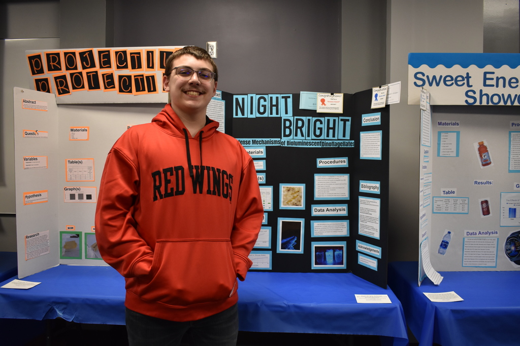 A student standing with his project