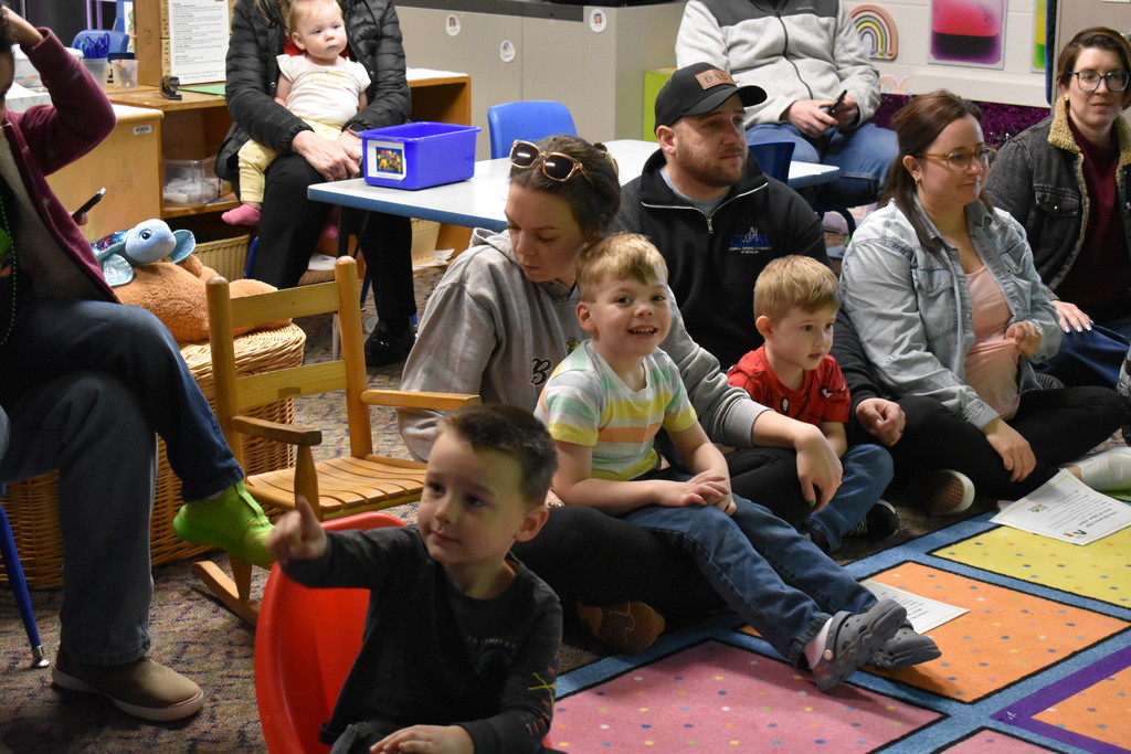 Children sitting in the laps of family members for story hour