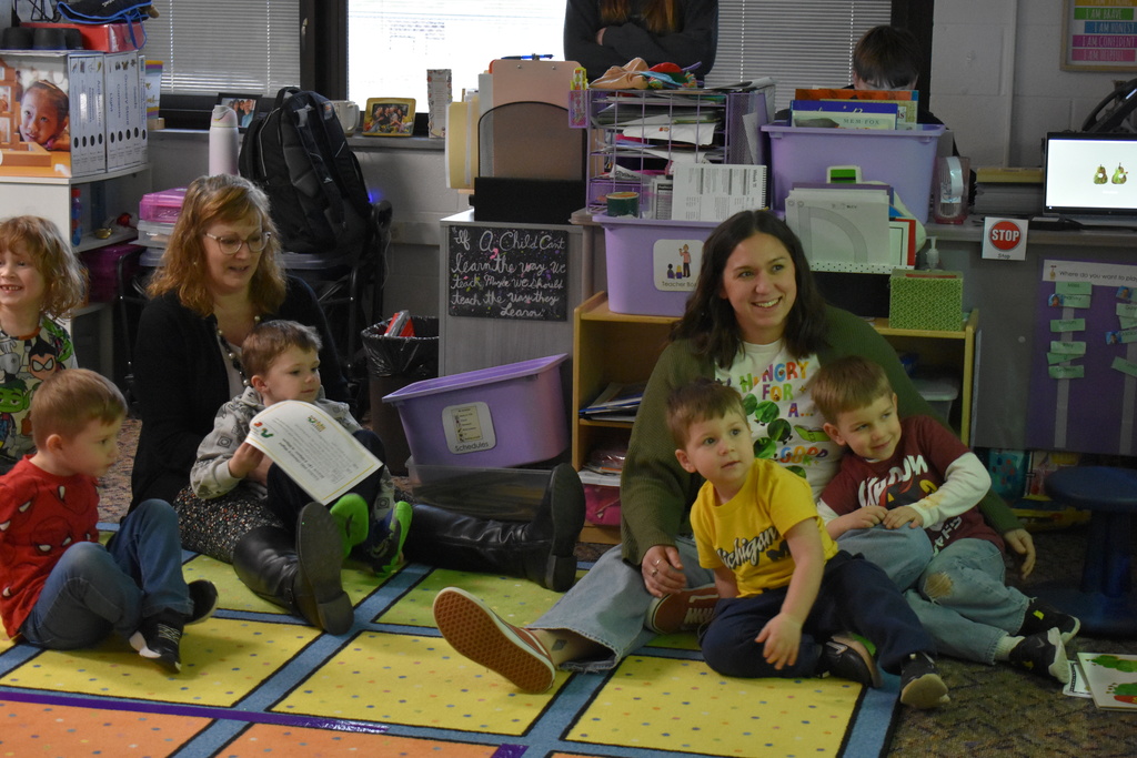Families with their students sitting on the floor during story hour