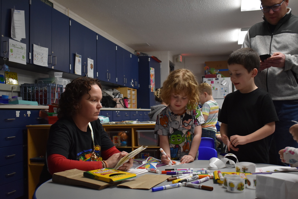 Students working on an art project while teachers assist
