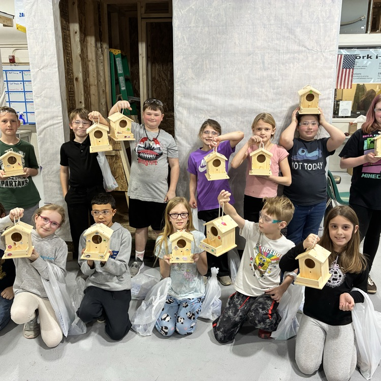 Elementary students posing with the bird houses they made
