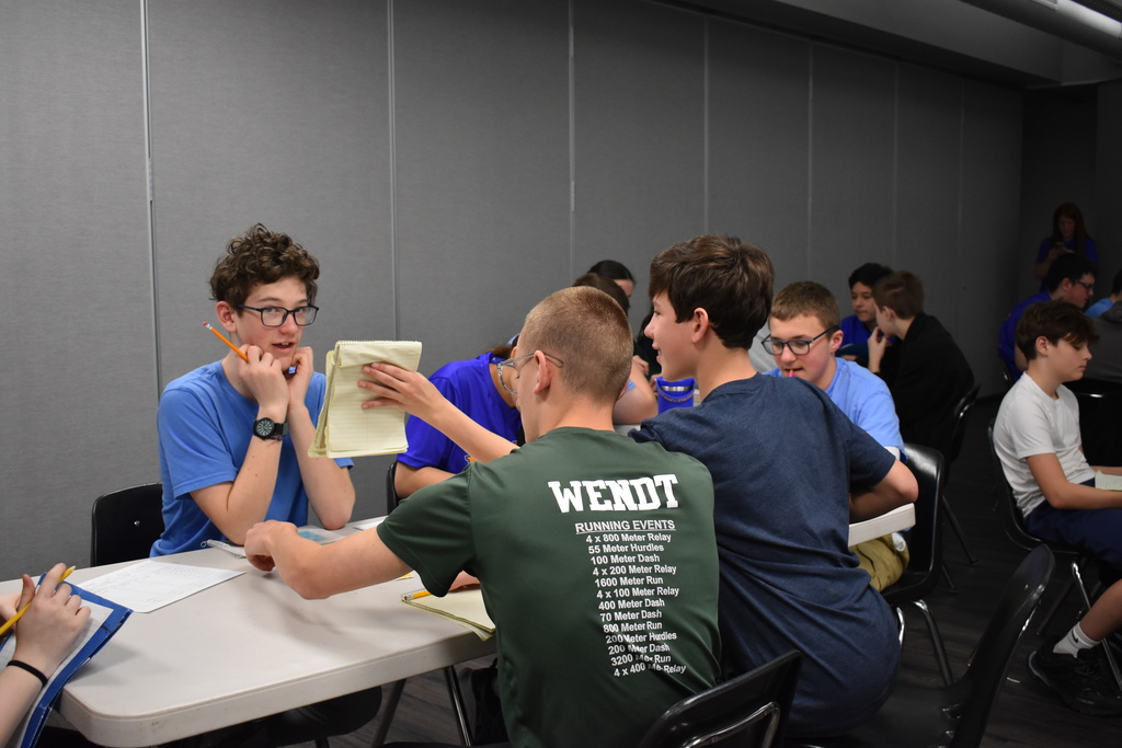 Students showing a note to another student in the middle of an equations game