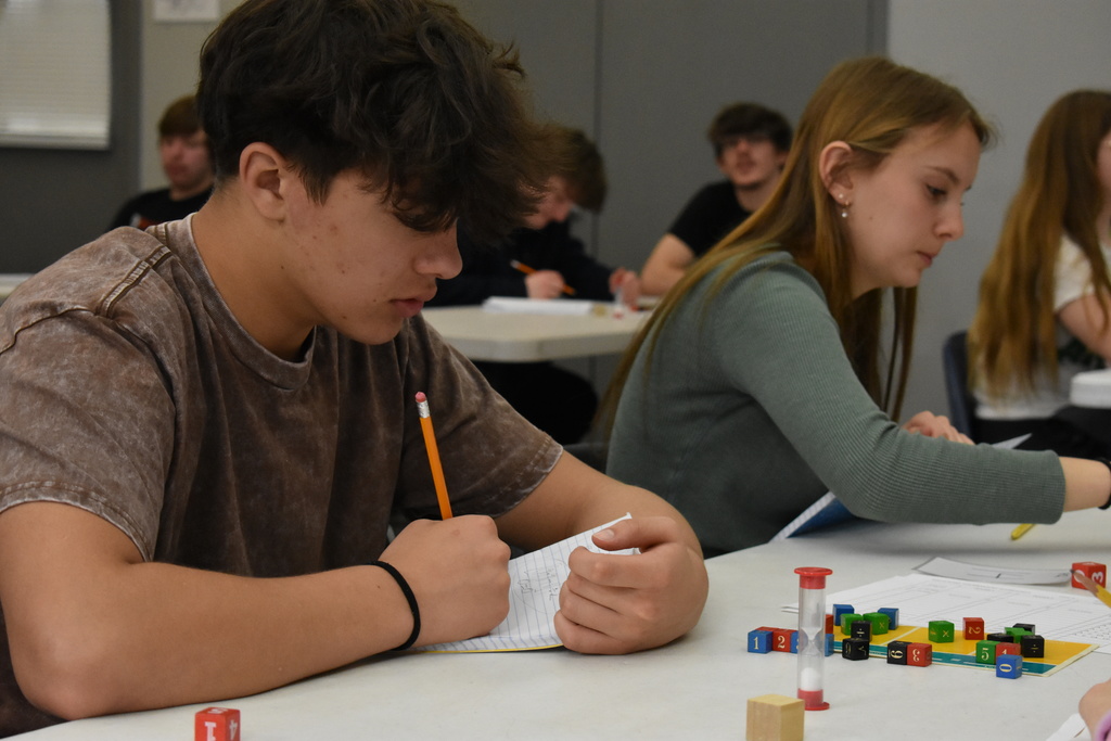 A student thinking about his next move in the middle of an equations game