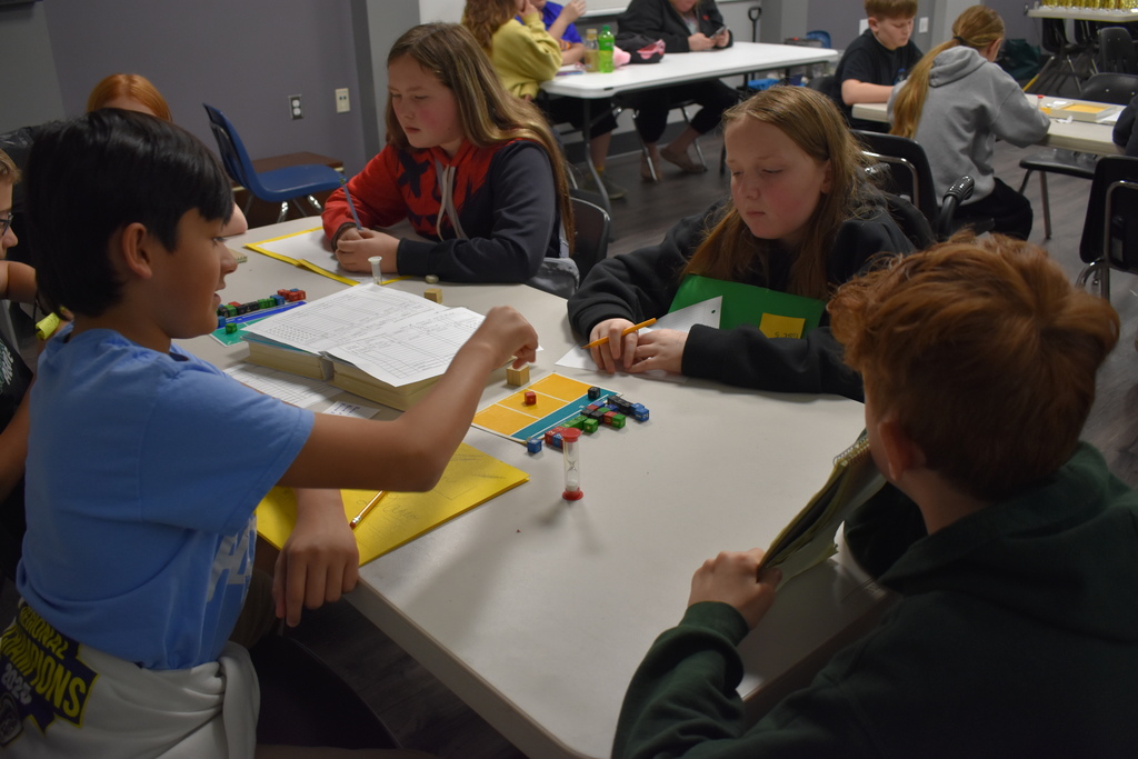 a group of middle school students in the middle of a game of equations
