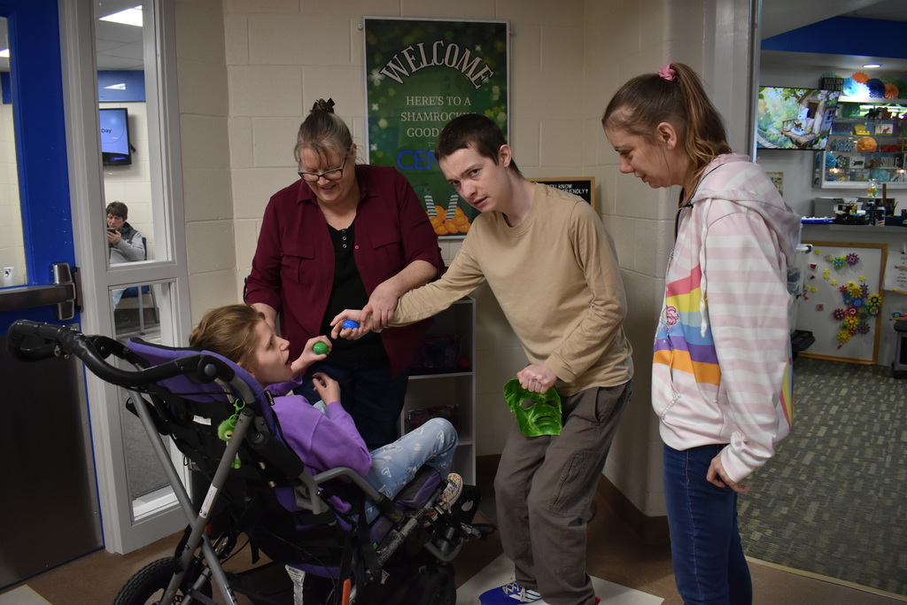A student helping another student find eggs while teachers look on