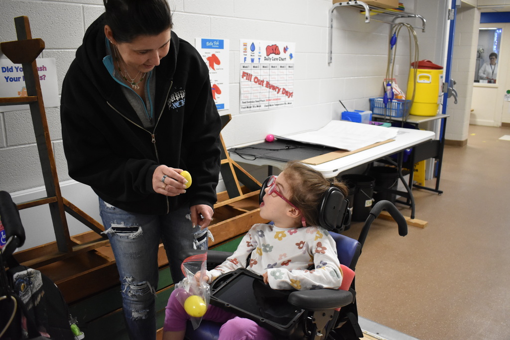 A student looking at her teacher as she collects a second egg