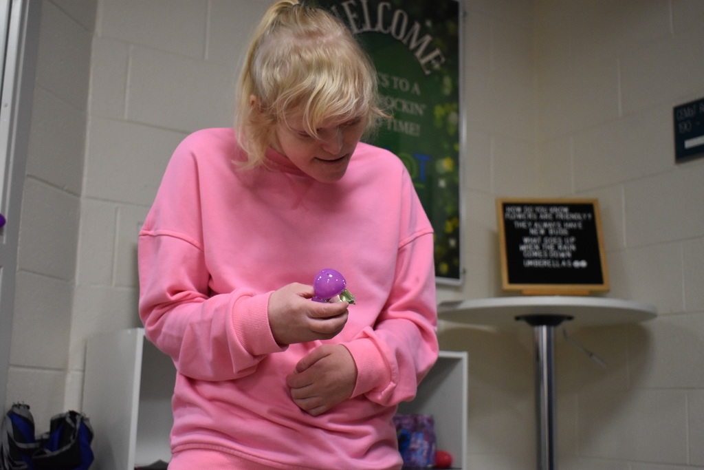 a student holding her egg and opening it with one hand