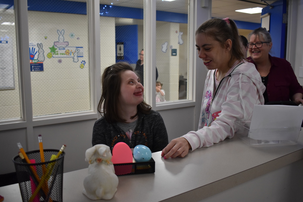 a very happy and excited student looking at her helpers as she finds an egg