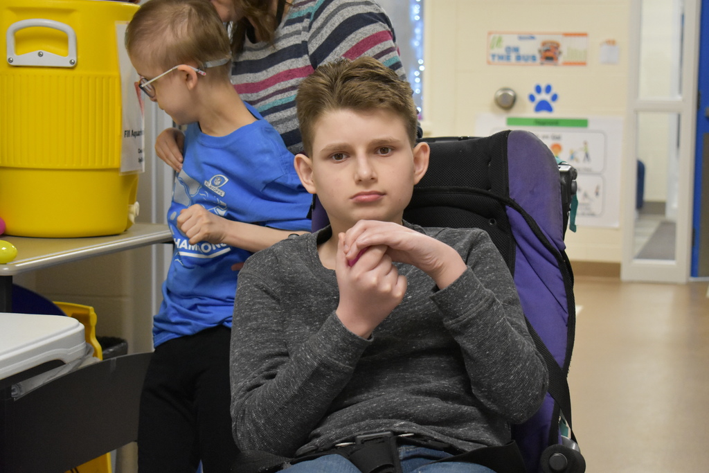 A student looking into the camer with an egg in his hand