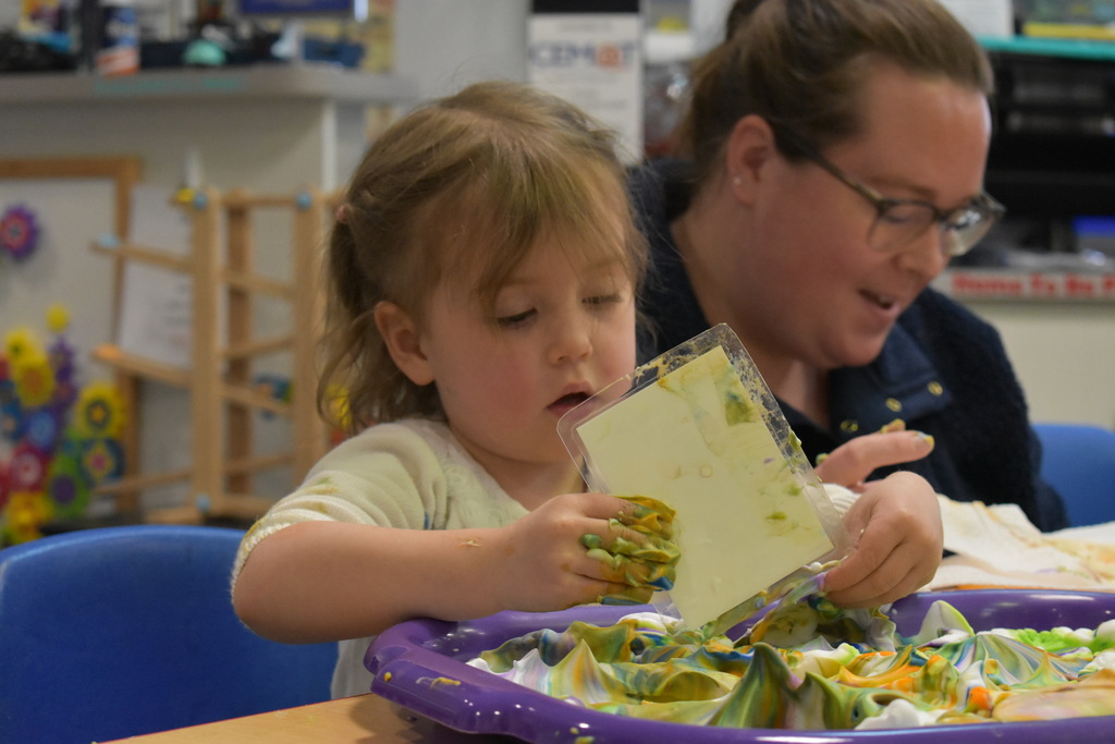 A little girl dying her egg and wiping off the extra color