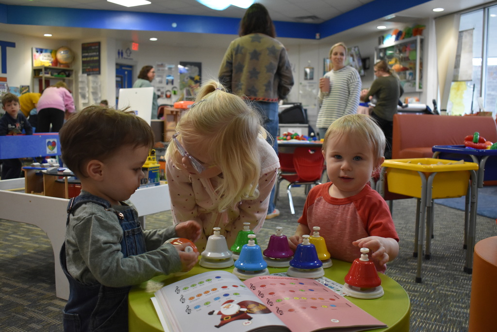 three children playing with musical instruments together