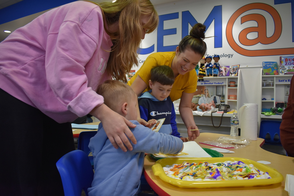 Two parents and their children dying eggs together