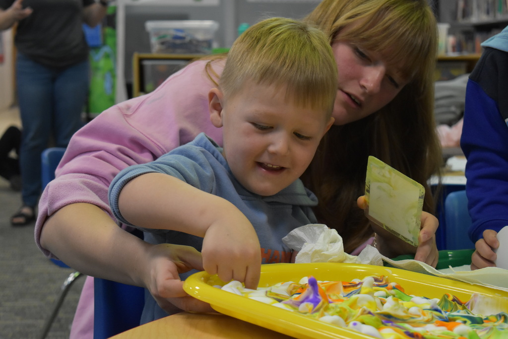 A parent and child dying eggs together