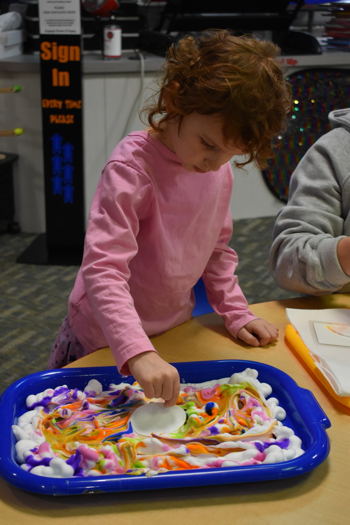 A little girl dying her egg