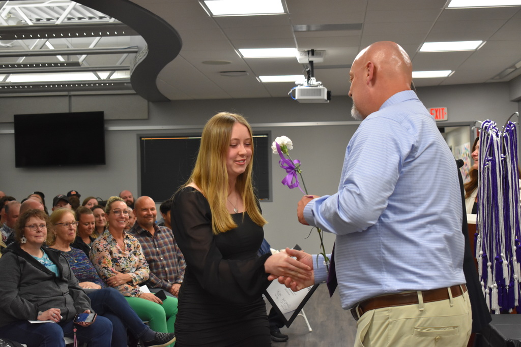 A student shaking hands and receiving an award