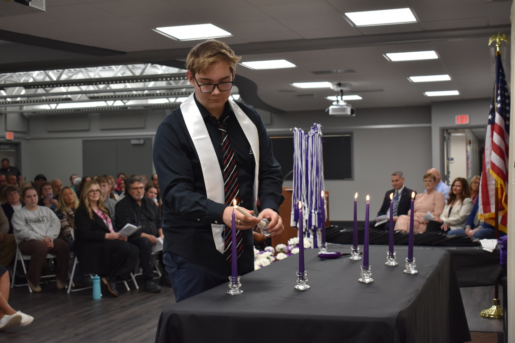 A student lighting a candle