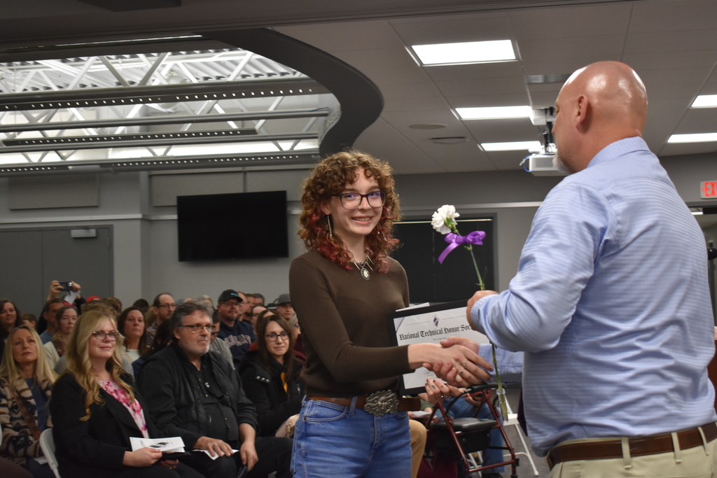 A student shaking hands and receiving an award