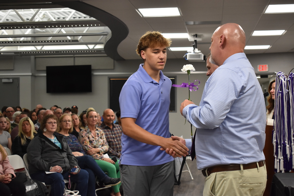 A student shaking hands and receiving an award