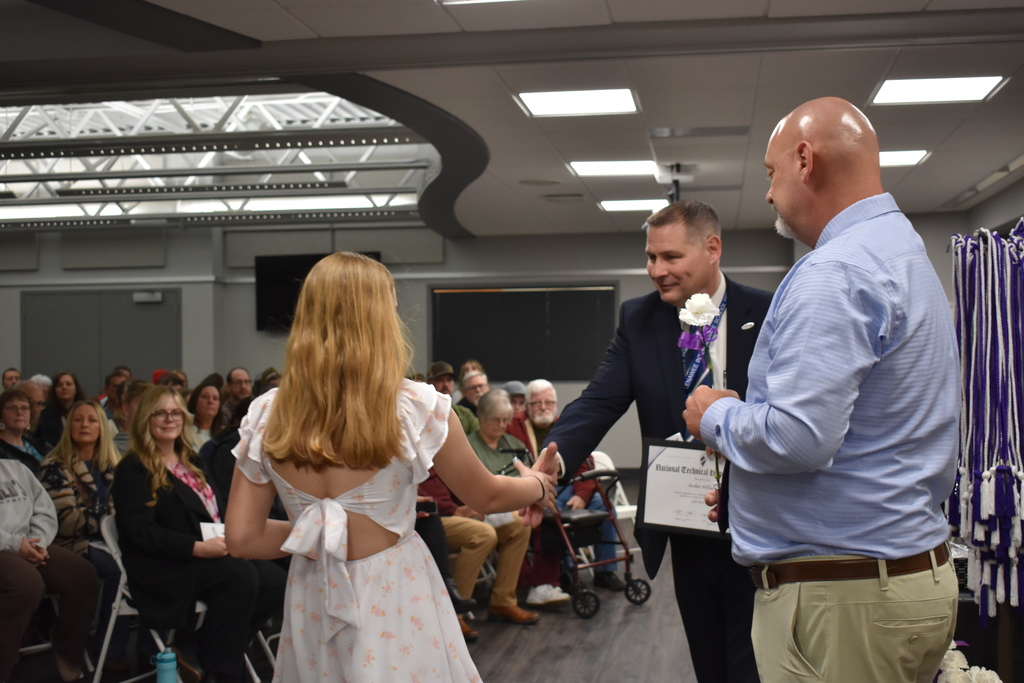 A student shaking hands and receiving an award