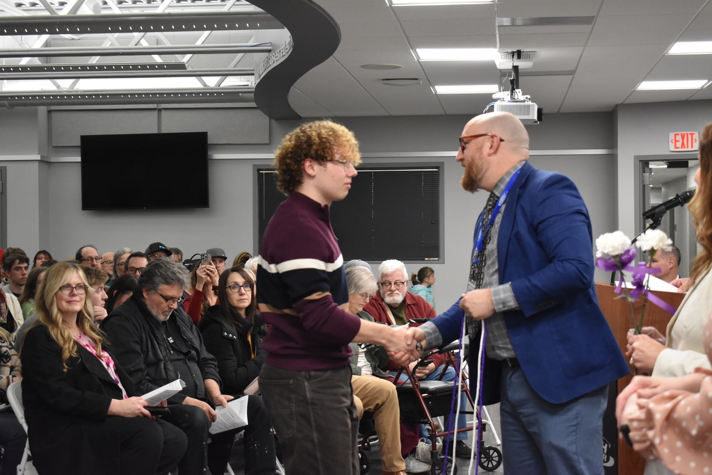 A student shaking hands and receiving an award