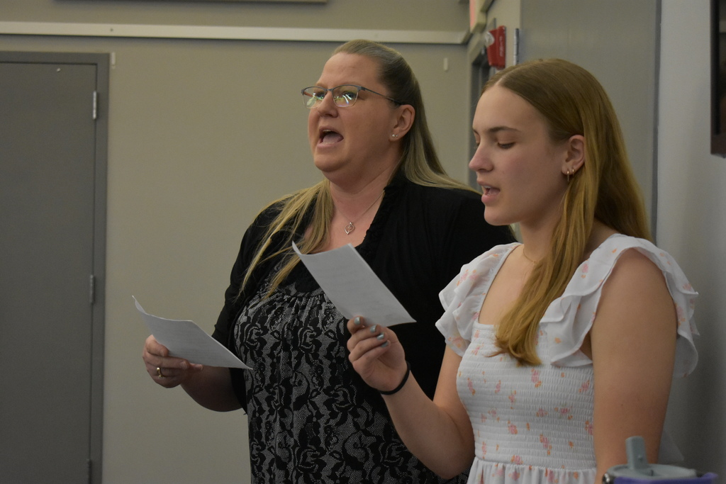 Mother and daughter singing the national anthem