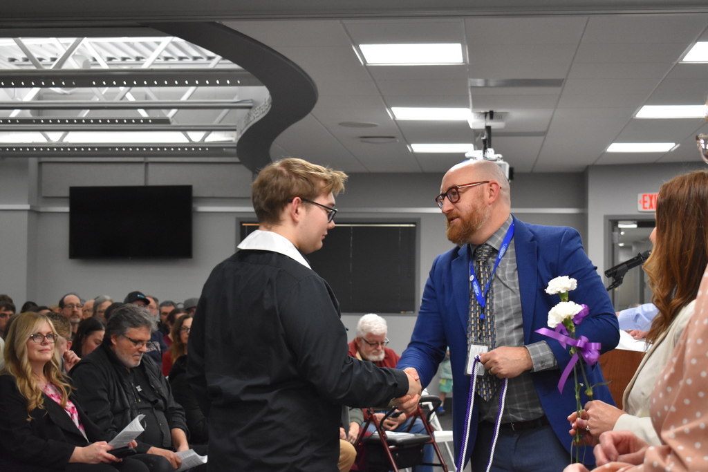 A student shaking hands and receiving an award