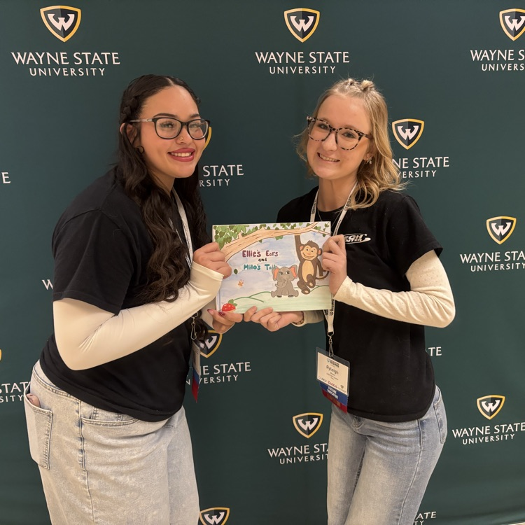 Two students posing with their contest materials 