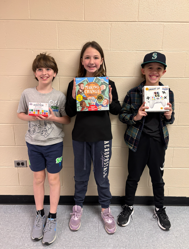 3 students posing with activities