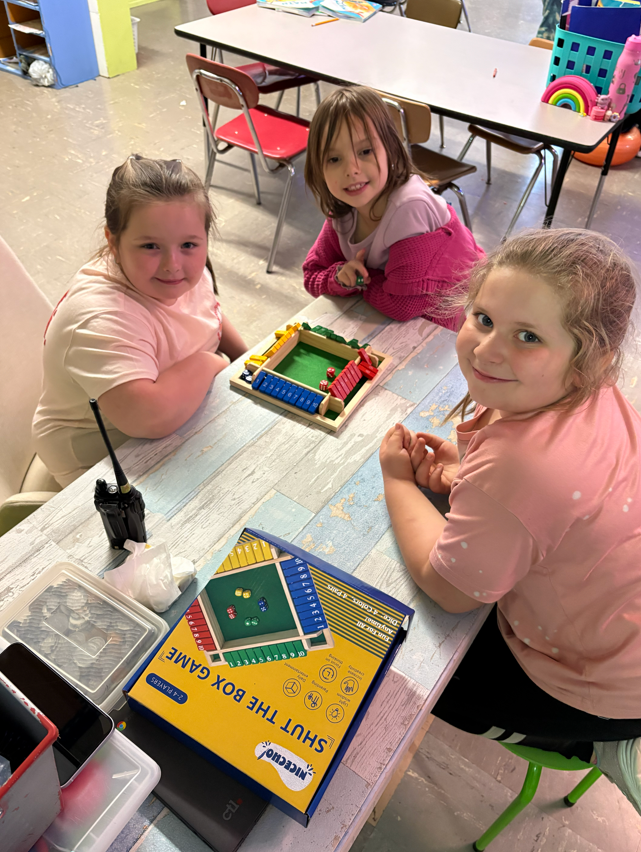 Three students posing while playing a game