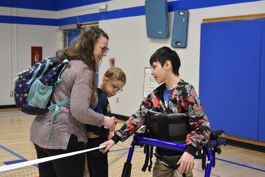 Two students at the net with the help of a teacher