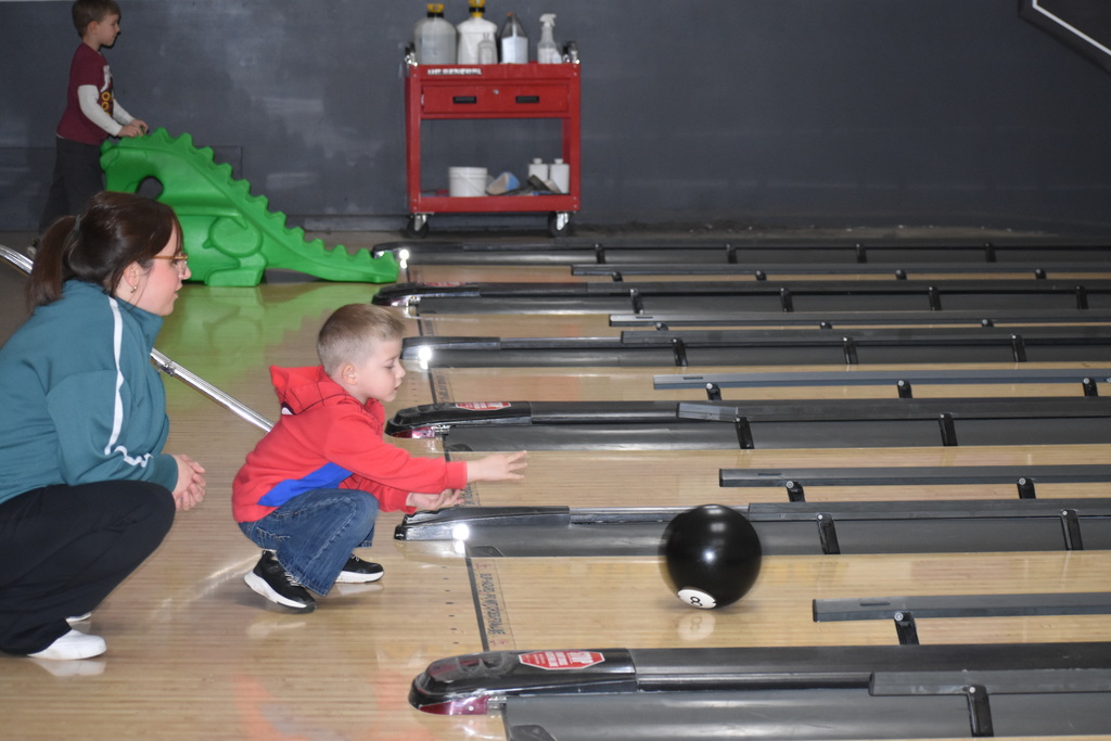 A student releasing his bowling ball down the alley