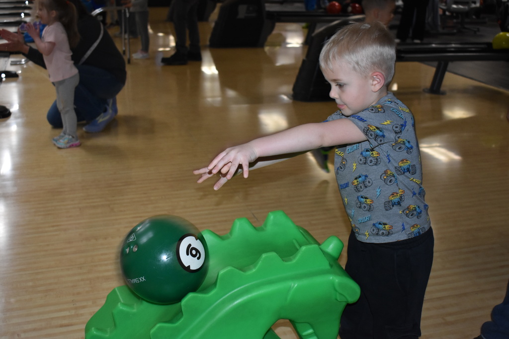 A student rolling his bowling ball down the ramp